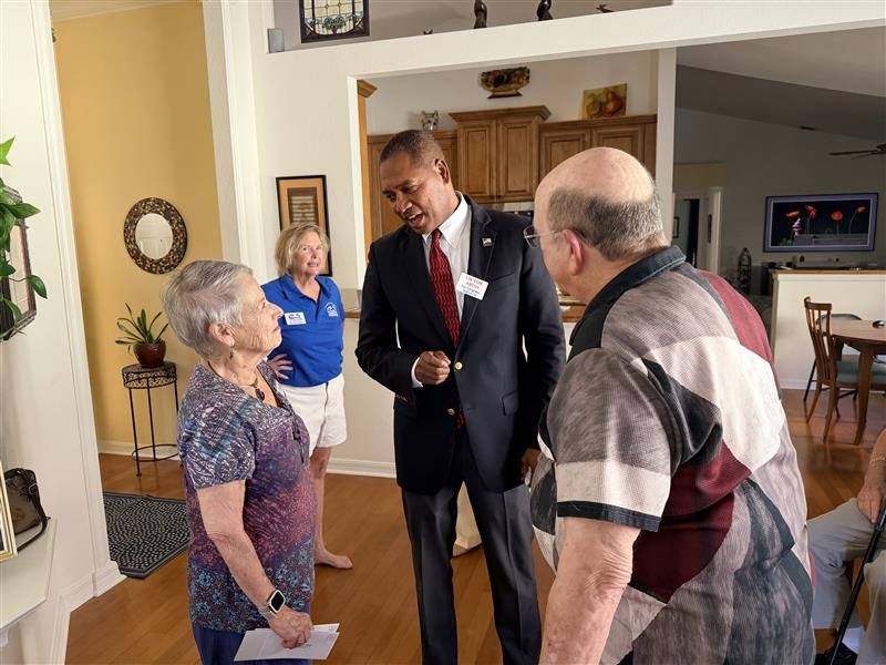 Victor Arias speaks with community members during an indoor gathering.